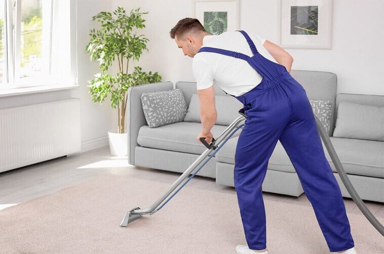 Service Technician Cleaning Carpet in Residence